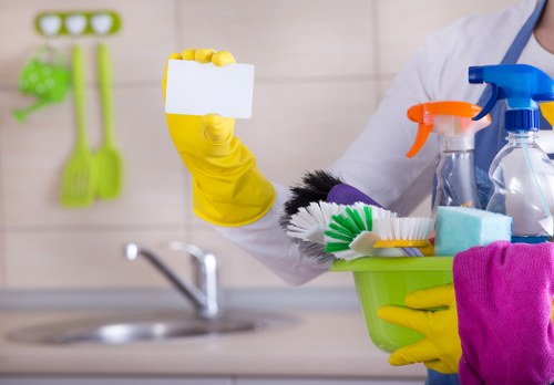 Staff member using cleaning products safely with PPE