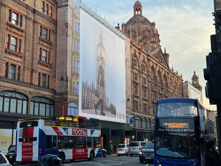 A panoramic view of a busy urban street lined with historic and modern buildings in Knightsbridge, featuring ornate facades, large windows, and decorative architectural elements. The street is bustlin